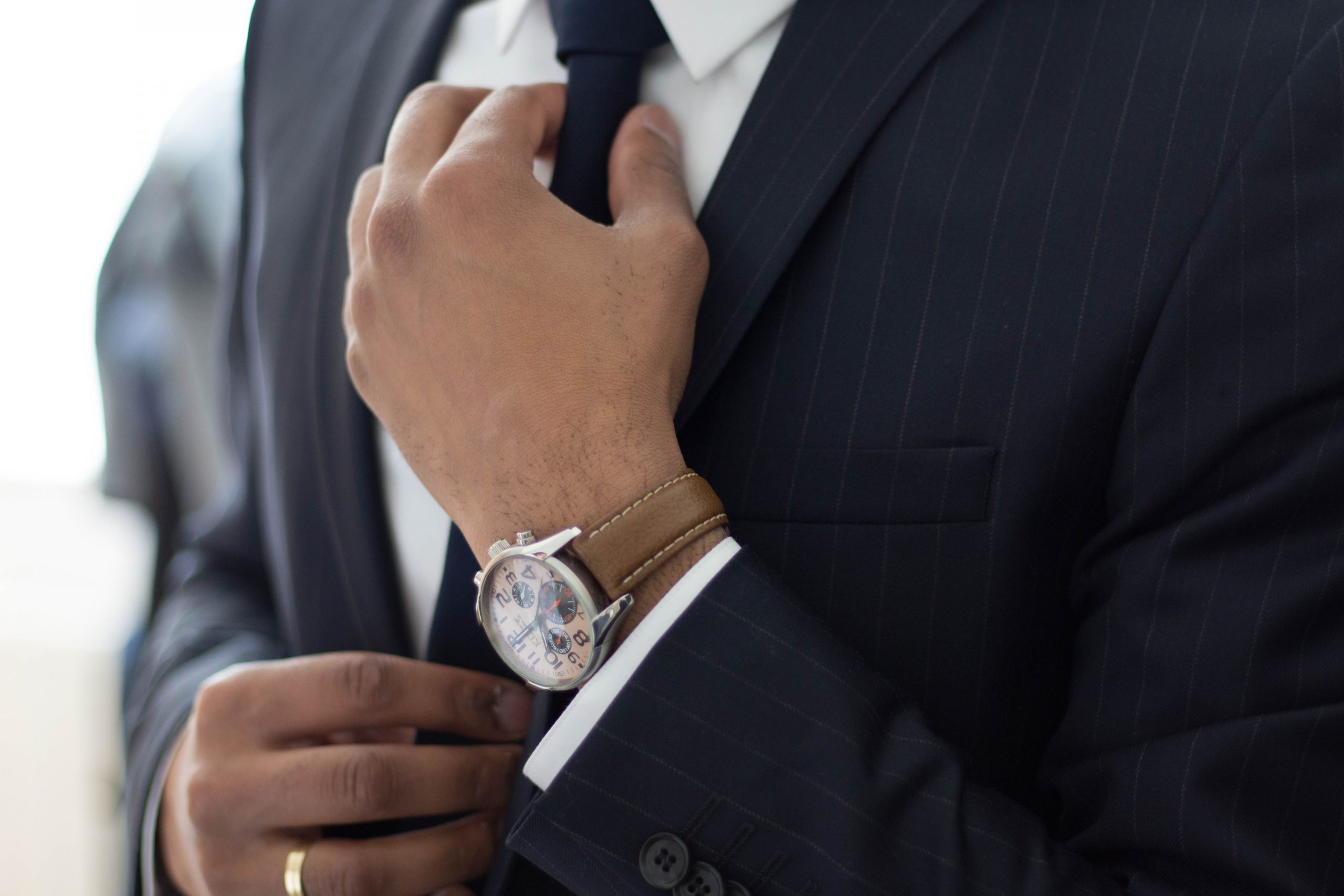 man adjusting suit tie